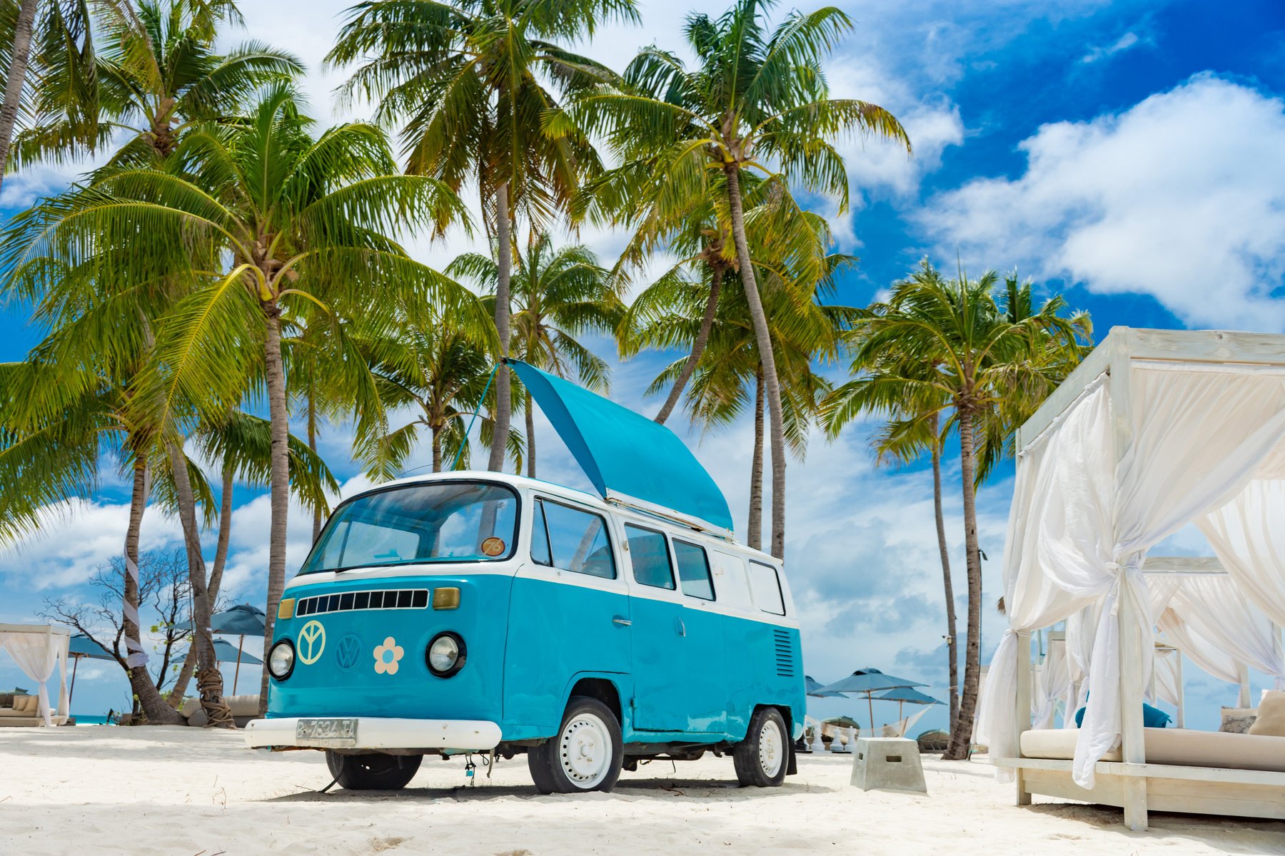 Vintage camper on beach under palms